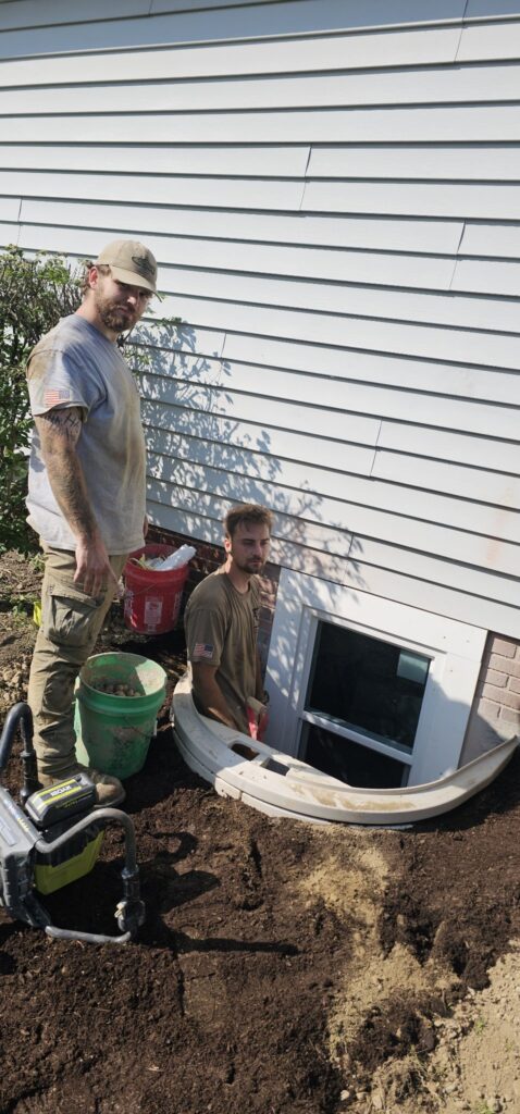 Crew installing egress window, wide view